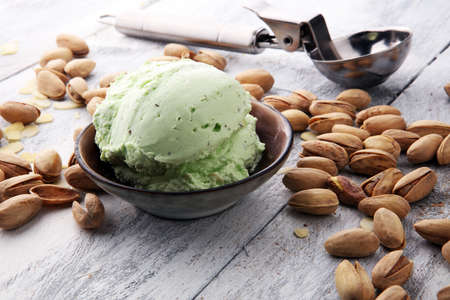 scoop of pistachio ice cream with pistachios on wooden backgroundの写真素材