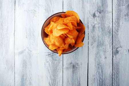 Crispy potato chips. Paprika chips on white wooden backgroundの写真素材
