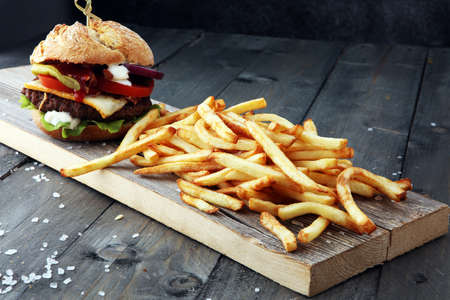 fresh tasty burger and french fries on wooden tableの写真素材