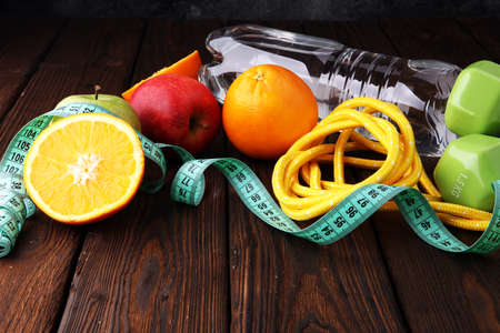 Fitness concept dumbbells, skipping rope, bottle water, apples and tape measure.の写真素材