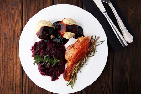 Crusty Christmas goose leg with braised red cabbage and dumplingsの写真素材