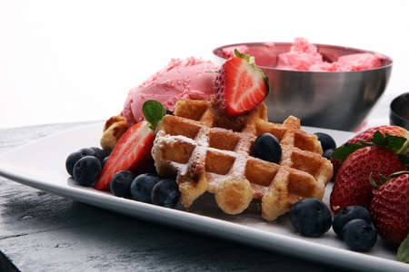 Plate of belgian waffles with strawberry ice cream, and fresh strawberriesの写真素材