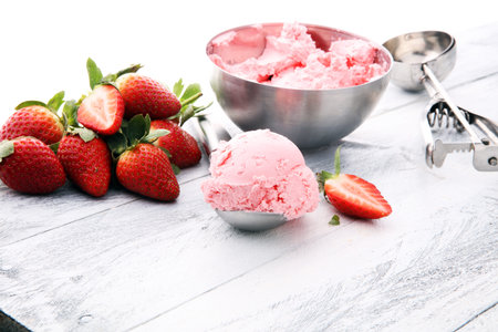 Delicious strawberry ice cream scoop with fresh strawberries on wooden backgroundの写真素材