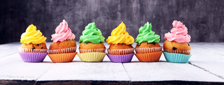 Tasty cupcakes on wooden background. Birthday cupcake in rainbow colors