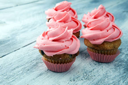 Tasty cupcakes on wooden background. Birthday cupcake in pink colorの写真素材