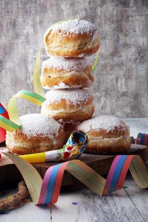 German donuts with jam and icing sugar. Carnival powdered sugar raised donuts with paper streamers.の写真素材