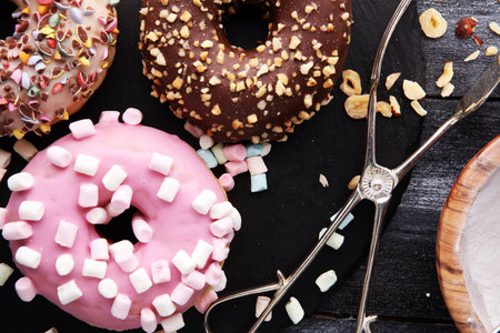 assorted donuts with chocolate frosted, pink glazed and sprinkles donuts.の写真素材