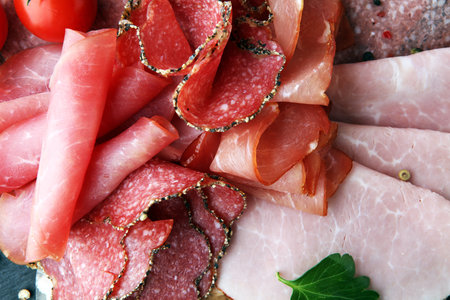 Food tray with delicious salami, pieces of sliced ham, sausage, tomatoes, salad and vegetable - Meat...