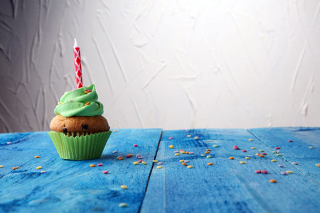 Tasty cupcakes on wooden background. Birthday cupcake in rainbow colors