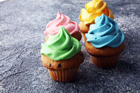 Tasty cupcakes on grey background. Birthday cupcake in rainbow colors