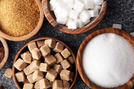 Various types of sugar, brown sugar and white on grey tableの写真素材