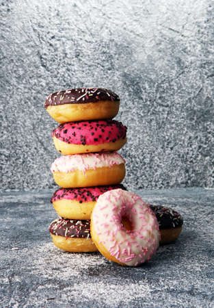 donuts in different glazes on grey background. birthday bakery conceptの写真素材
