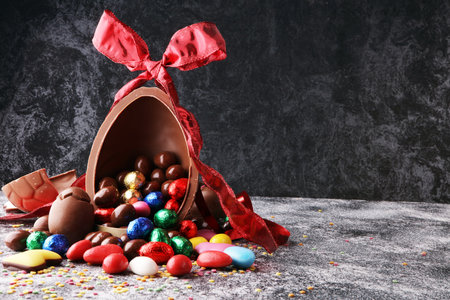 Chocolate Easter eggs with color ribbon bows on vintage background
