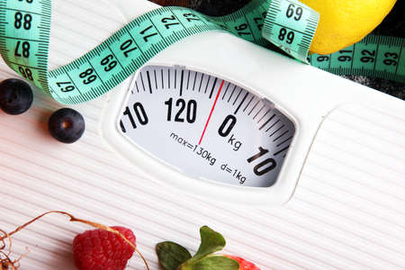 Healthy living or Diet concept. Fruits with measuring tape and a weight scaleの写真素材