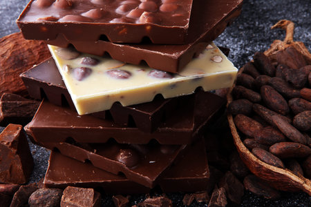 Chocolate bars on dark background with chocolate tower