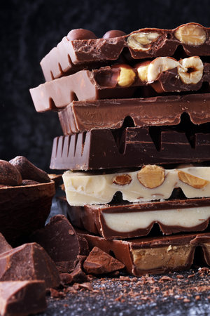 Chocolate bars on dark background with chocolate tower