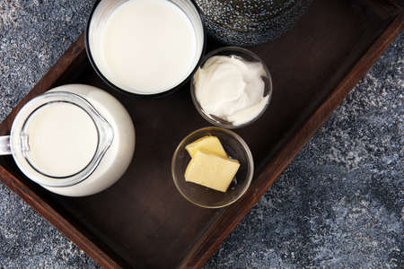 milk products - tasty healthy dairy products on a table sour cream in a bowl, cream and milk jarの写真素材