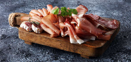 Food tray with delicious salami, pieces of sliced ham, . Meat platter with selectionの写真素材