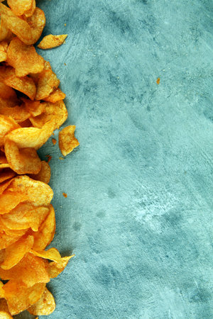 Crispy potato chips. Paprika chips on table. Spicy crunchy chips.