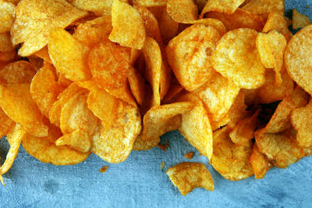 Crispy potato chips. Paprika chips on table. Spicy crunchy chips.の写真素材