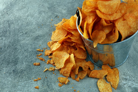 Crispy potato chips. Paprika chips on table. Spicy crunchy chips.の写真素材