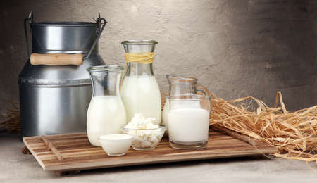 milk products. tasty healthy dairy products on a table on. sour cream in a bowl, cottage cheese bowl, cream in a a bank and milk jar, glass bottle and in a glassの写真素材
