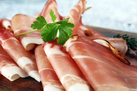 Italian prosciutto crudo or jamon with parsley. Raw ham.