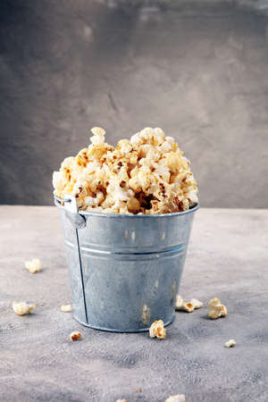 Salt popcorn or sweet popcorn on old grey backgroundの写真素材