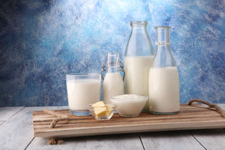 milk products. tasty healthy dairy products on a table on. sour cream in a bowl, cottage cheese bowl, cream in a a bank and milk jar, glass bottle and in a glassの写真素材