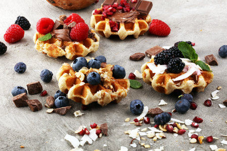 Belgian waffles with pomegranate and raspberries, homemade healthy breakfast with mint and hazelnut butterの写真素材