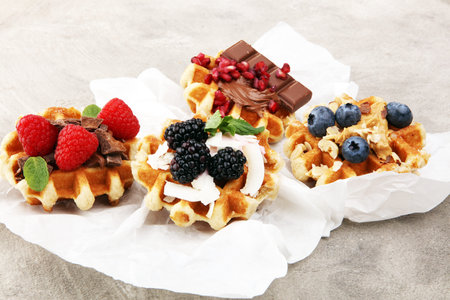 Belgian waffles with pomegranate and raspberries, homemade healthy breakfast with mint and hazelnut butterの写真素材