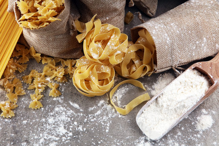 Various mix of pasta on grey rustic background. Making homemade pastaの写真素材
