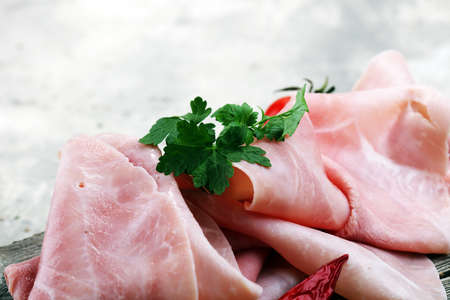 Sliced ham on wooden background. Fresh prosciutto. Pork ham sliced.の写真素材
