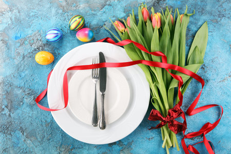 Festive table setting for Easter with fork, knife and tulipの写真素材