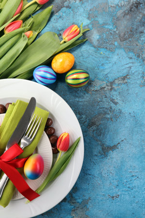 Festive table setting for Easter with fork, knife and tulip
