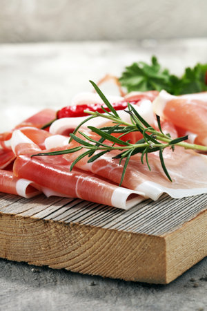 Italian prosciutto crudo or jamon with rosemary. Raw ham.の写真素材