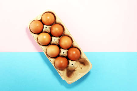 Egg. Fresh farm eggs flat lay on colored paperの写真素材