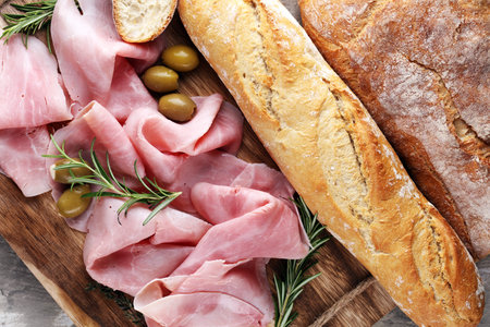 Sliced ham on wooden cutting board. Fresh prosciutto. Pork ham sliced.