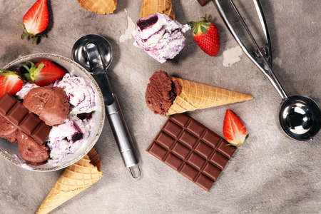 Chocolate coffee ice cream ball in a bowl and strawberry and vanilla and ice conesの写真素材