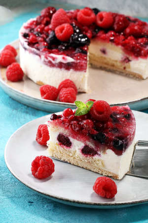 raspberry cake and many fresh raspberries. fresh spring cream cake with blackberries, blueberries and raspberriesの写真素材