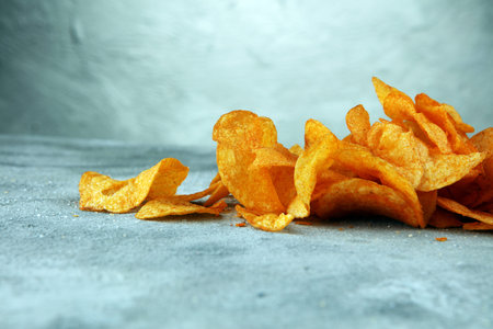 Crispy potato chips. Paprika chips on table. Spicy crunchy chips.