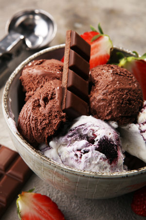 Chocolate coffee ice cream ball in a bowl and strawberry and vanilla and ice cones