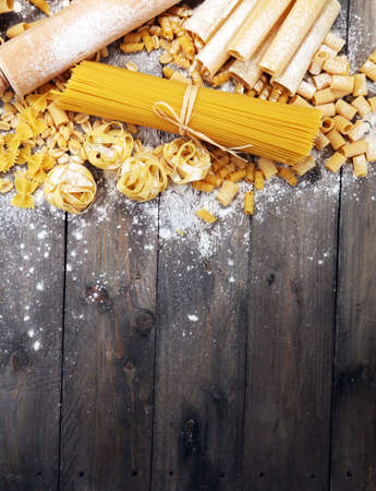 Various mix of pasta on grey rustic background. Making homemade pastaの写真素材