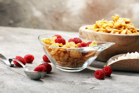 Bowl of Cornflakes and Raspberries for a healthy breakfast concept on rustic grey background