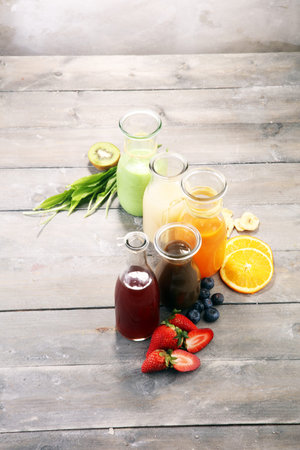 Selection of colorful smoothies on rustic background with vegetables and fruitsの写真素材