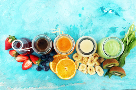 Selection of colorful smoothies on rustic background with vegetables and fruitsの写真素材