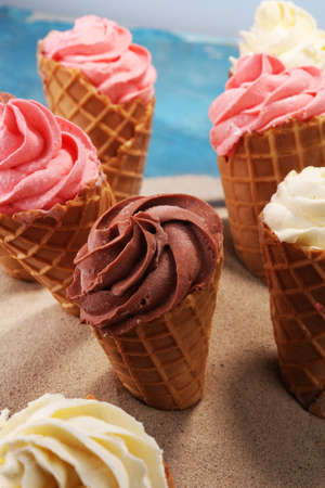 Vanilla frozen yogurt or soft ice cream in waffle cone. icecream with chocolate, strawberry and vanillaの写真素材