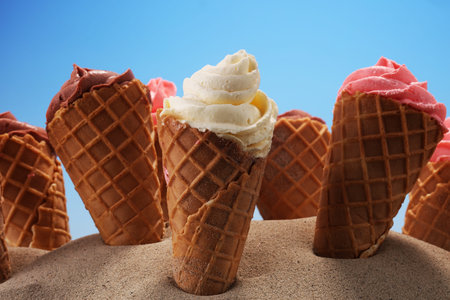 Vanilla frozen yogurt or soft ice cream in waffle cone. icecream with chocolate, strawberry and...