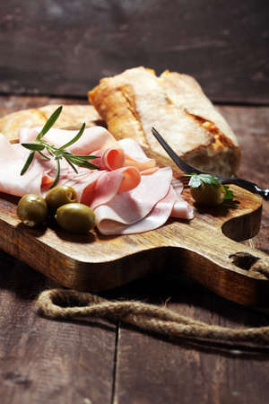 Sliced ham on wooden background. Fresh prosciutto. Pork ham sliced.の写真素材