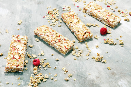 Granola bar. Healthy sweet dessert snack. Cereal granola bar with nuts, fruit, chocolate and berries on a stone table. の写真素材